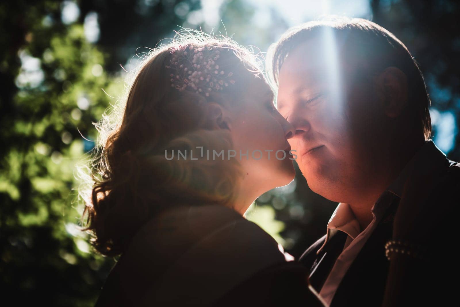 bride and groom on the background of trees and forest sun.