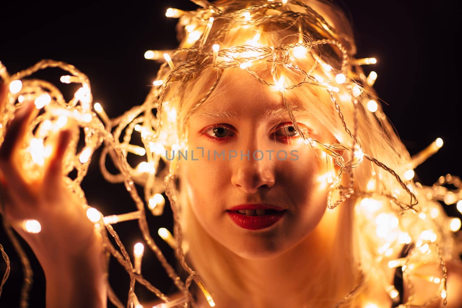 portrait of a girl with a garland on black background.