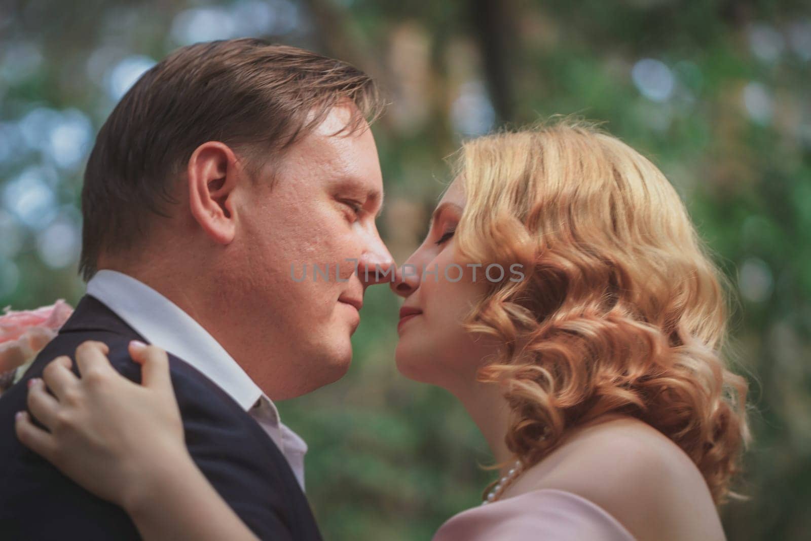 bride and groom on the background of trees and forest sun.