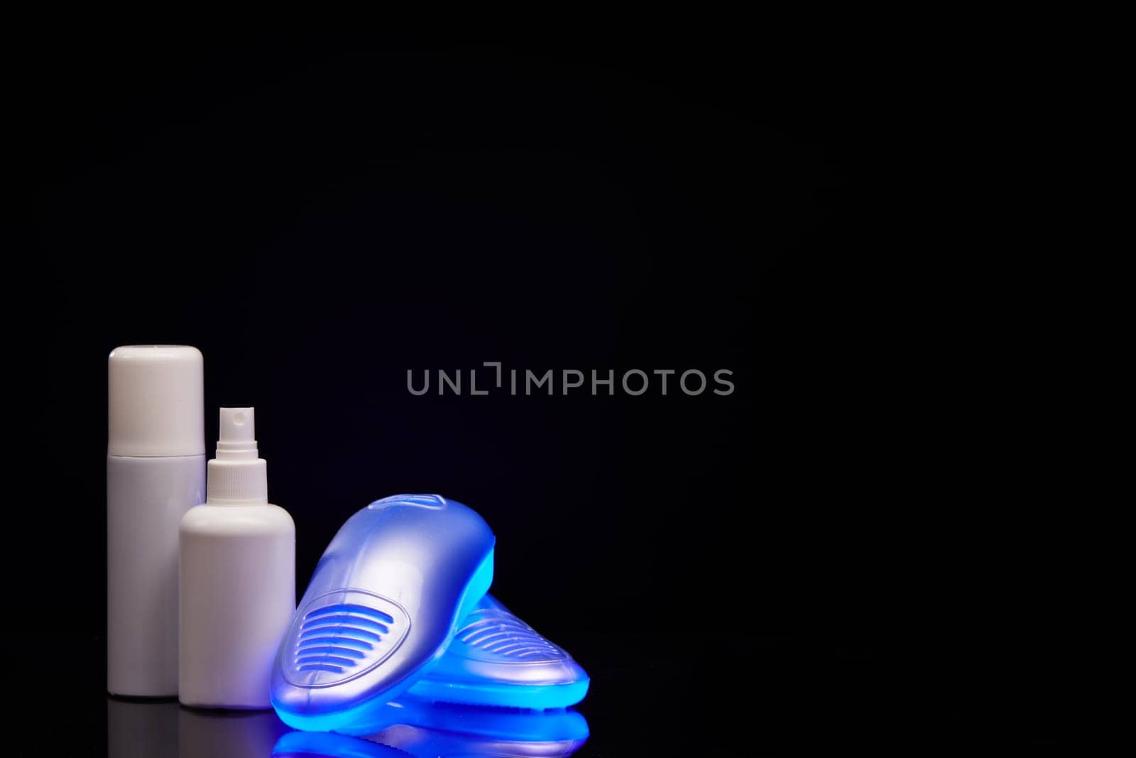 Electric shoes dryer with UV sterilization on a black background with copy space, Deodorant for shoe and antifungal agent. Shoe care products. Concept of healthy feet