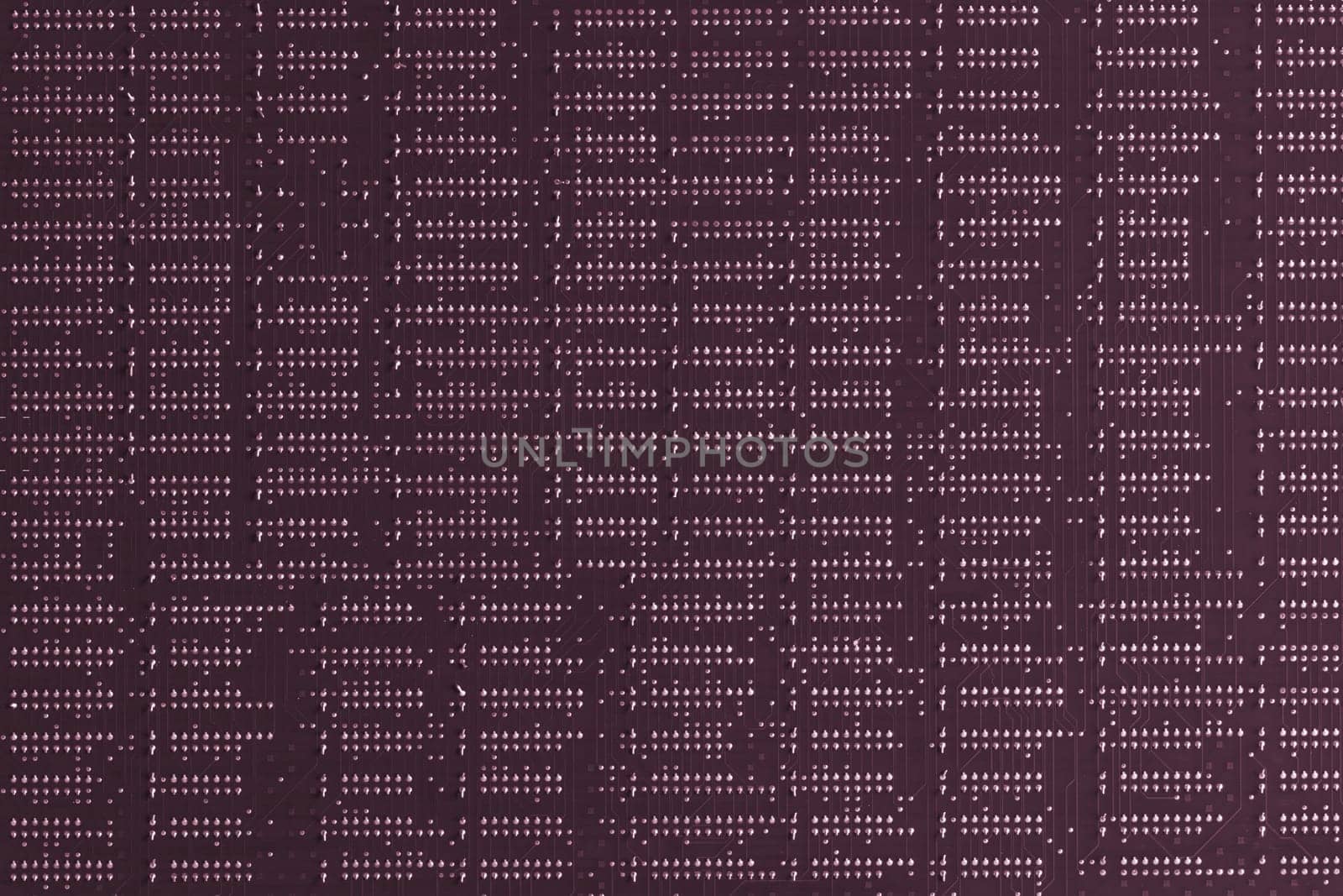 Computer technology background. Close up of purple digital electronic printed circuit board. Solder side. Macro of a PCB.