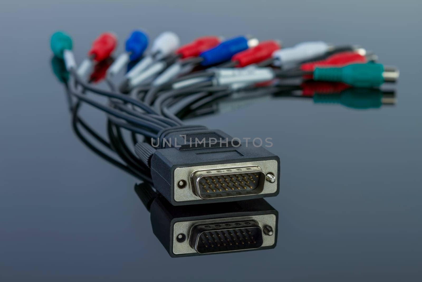 Tv audio video cable connector with multiples connections on black glossy background.