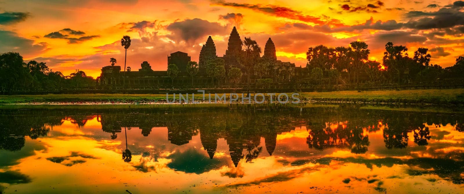 Angkor Wat temple reflecting in water of  Lotus pond at sunrise. Siem Reap. Cambodia. Panorama