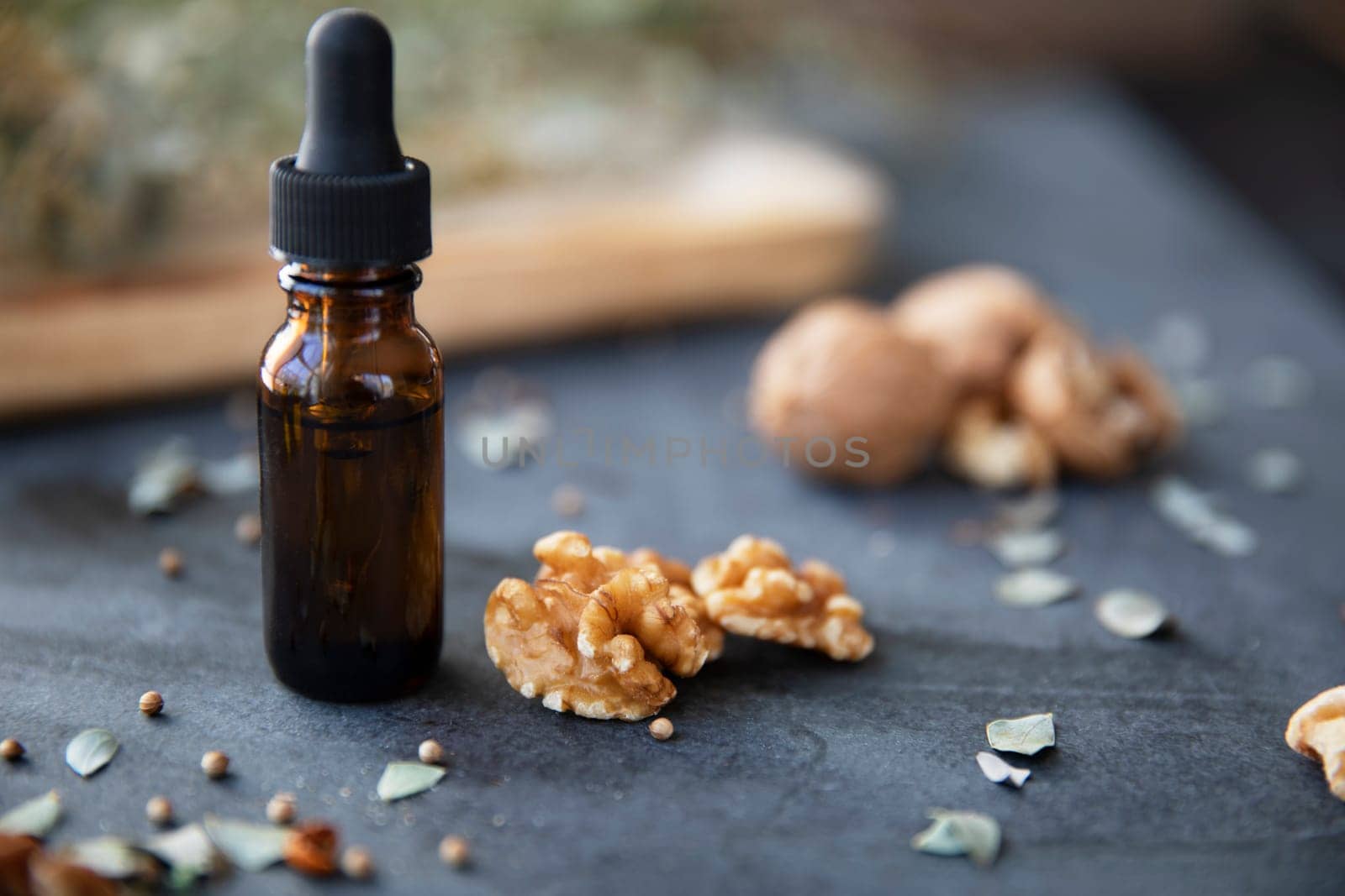 Walunts and dropper bottle of walnut oil on slate table.