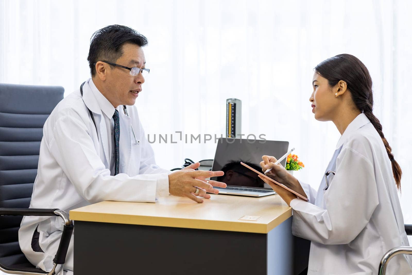 Two doctors in the hospital discuss the diagnos of the patient