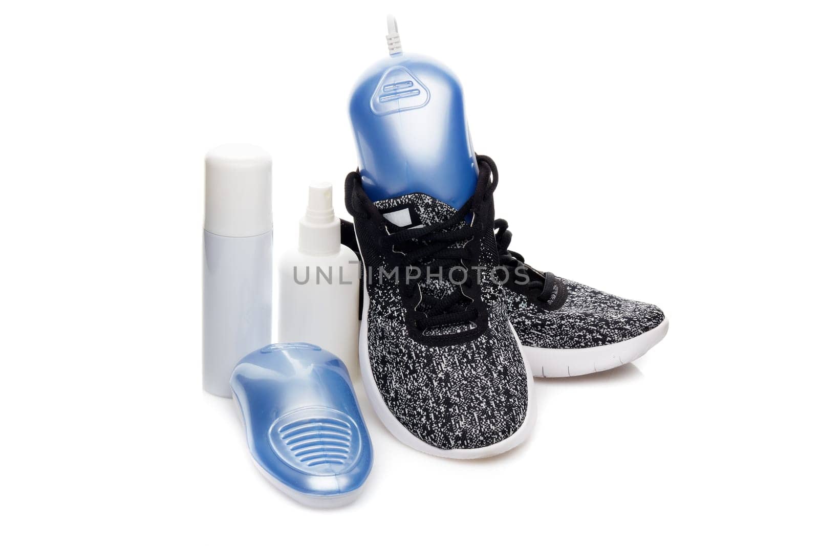 Sports shoes care. Electric shoes dryer with UV sterilization on a white background, Deodorant for shoe and antifungal agent. Shoe care products. Concept of healthy feet. Fitness and sport footwear