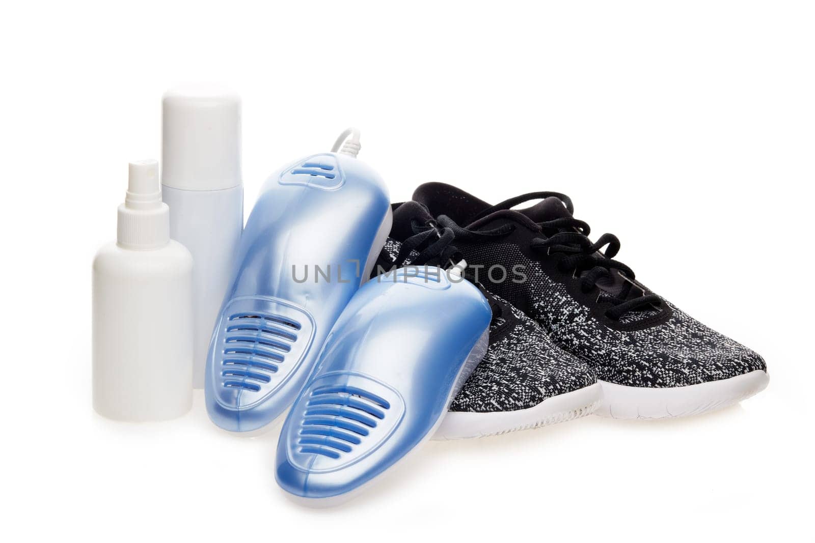 Sports shoes care. Electric shoes dryer with UV sterilization on a white background, Deodorant for shoe and antifungal agent. Shoe care products. Concept of healthy feet. Fitness and sport footwear