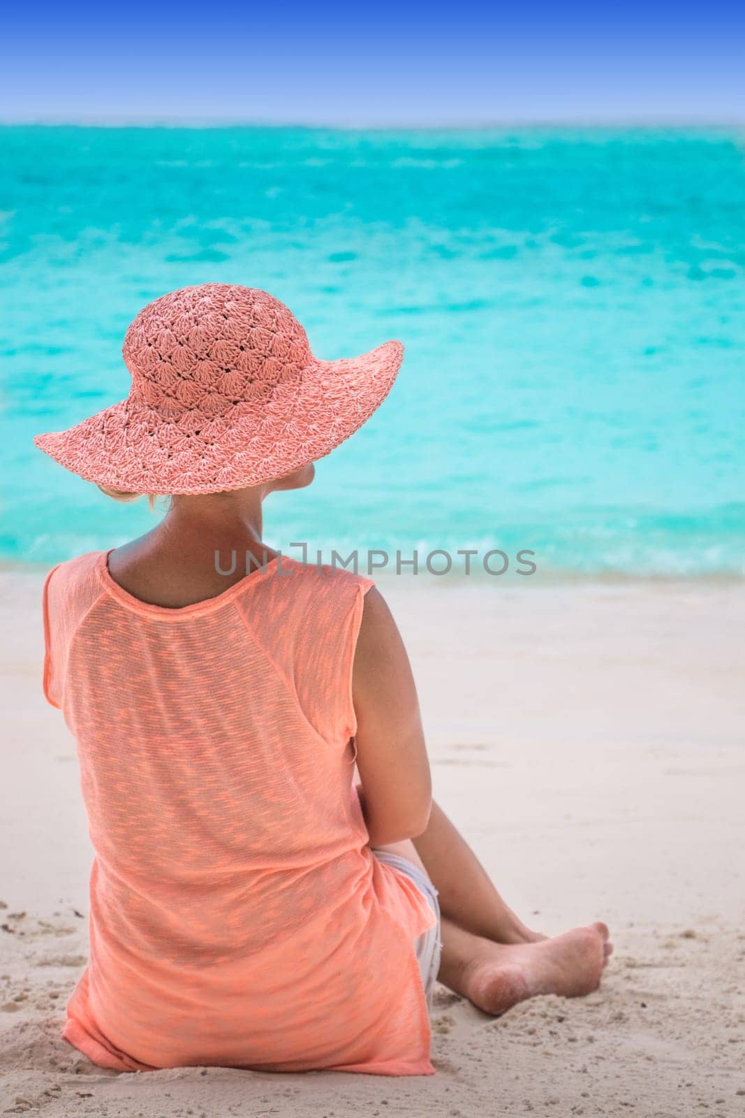 Girl in hat on coral beach