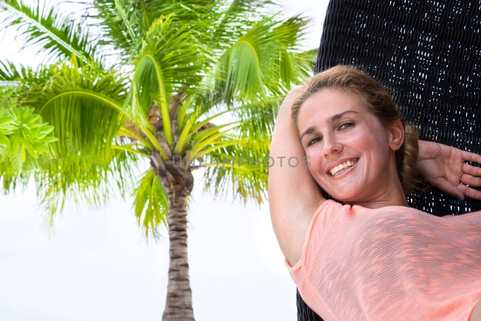Beautiful woman relaxes on a swing on the dream beach