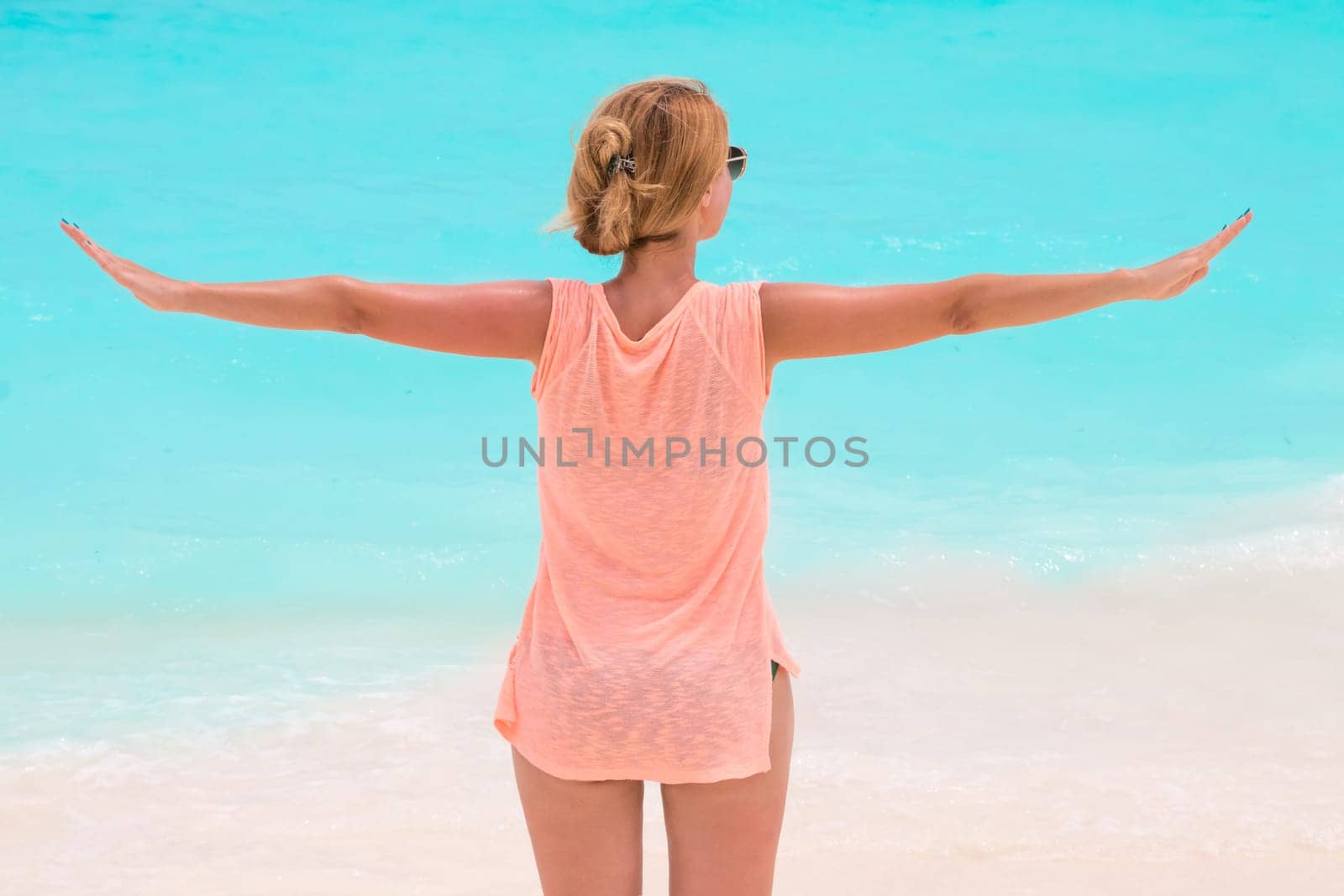 Gorgeous woman on the sandy beach with turquoise ocean