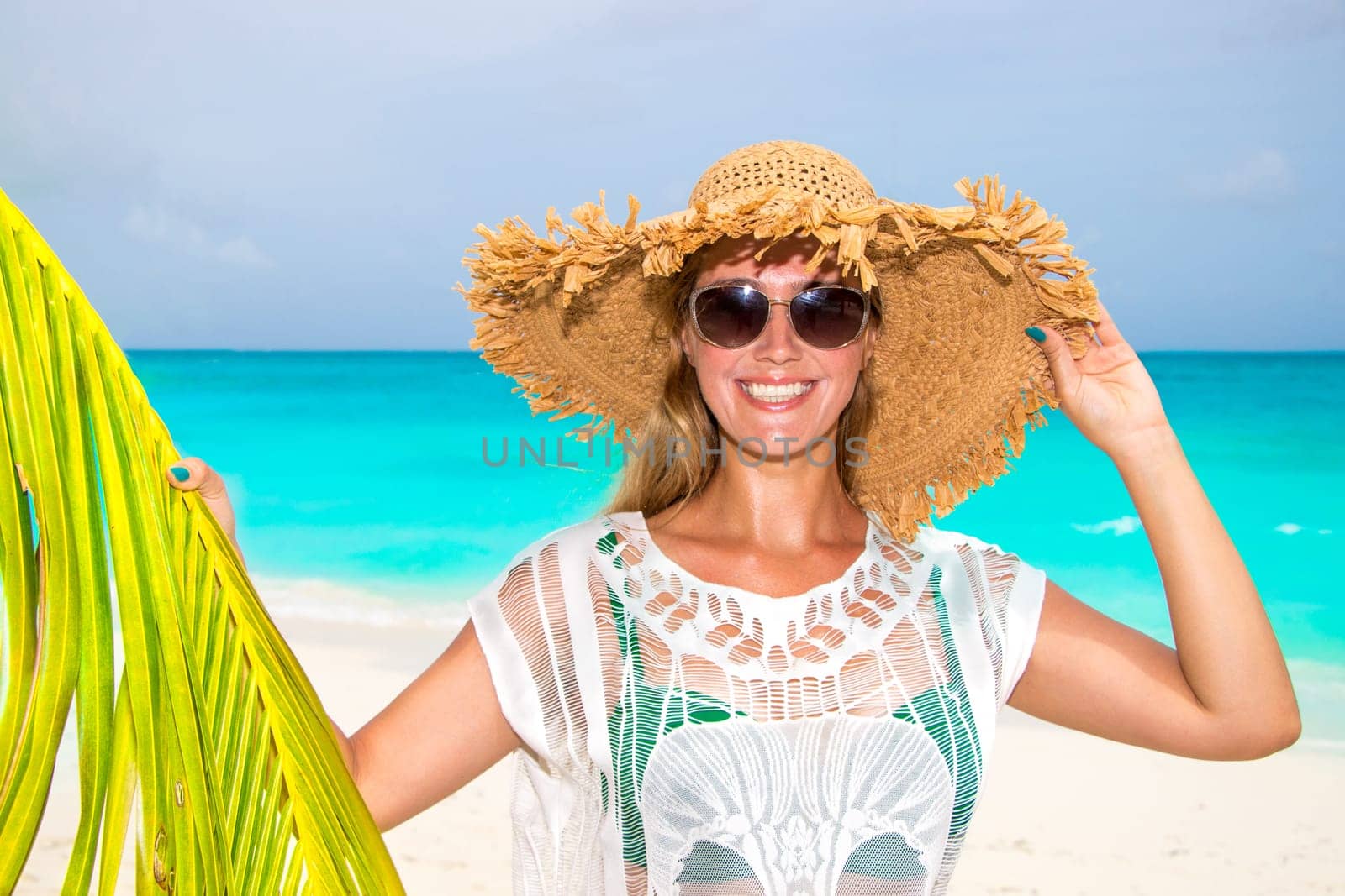 Gorgeous woman with sun hat on the dream beach