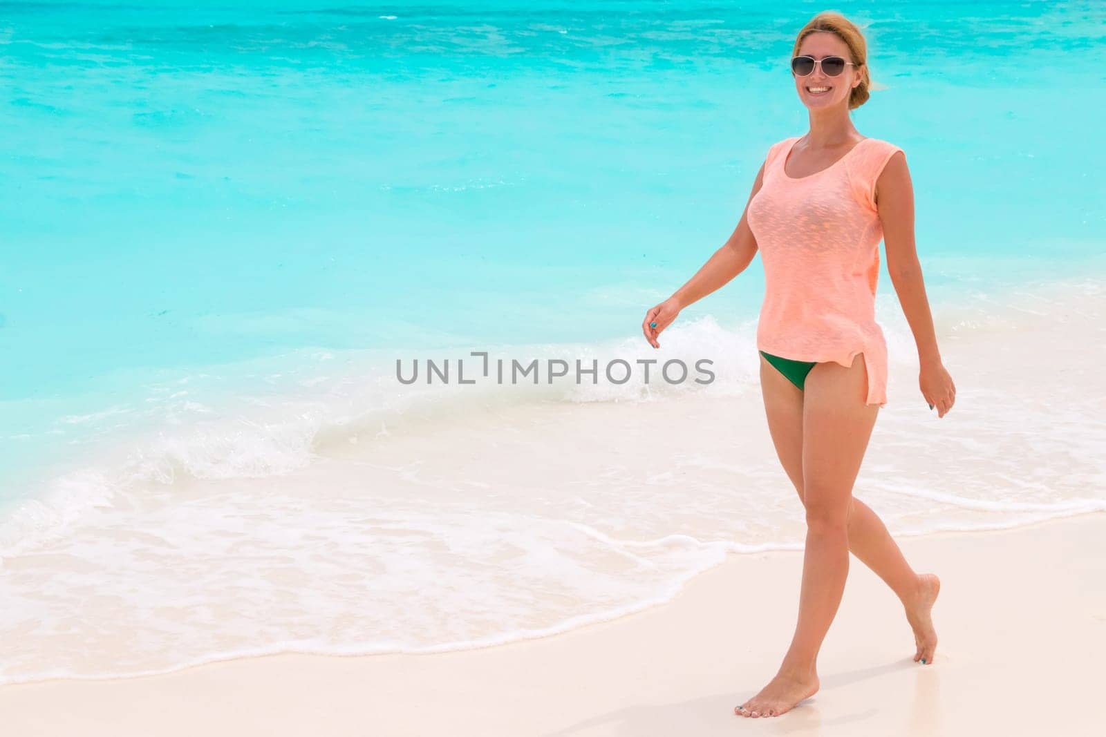 Gorgeous woman on the sandy beach with turquoise ocean