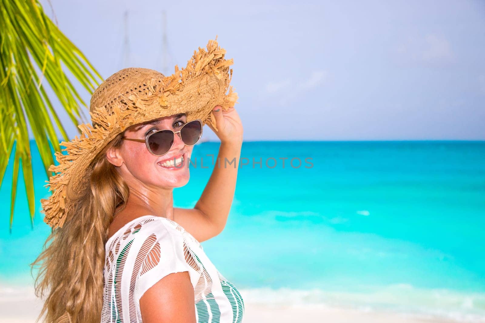 Gorgeous woman with sun hat on the dream beach