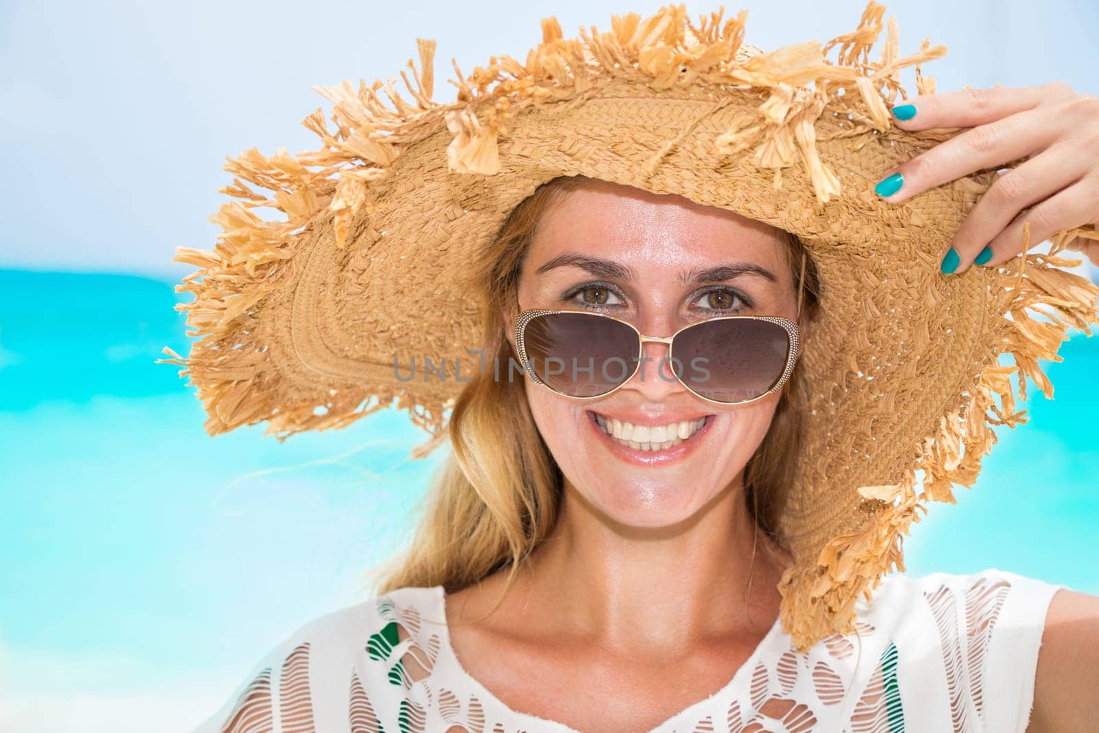 Gorgeous woman with sun hat on the dream beach