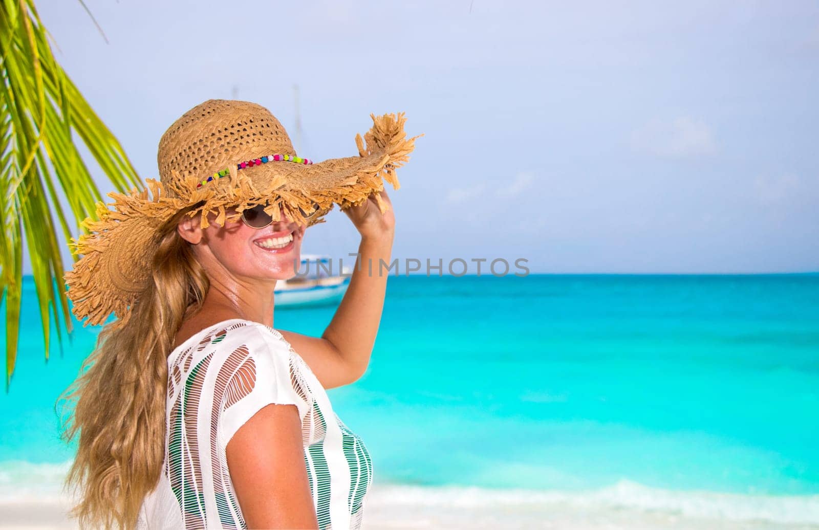 Gorgeous woman with sun hat on the dream beach