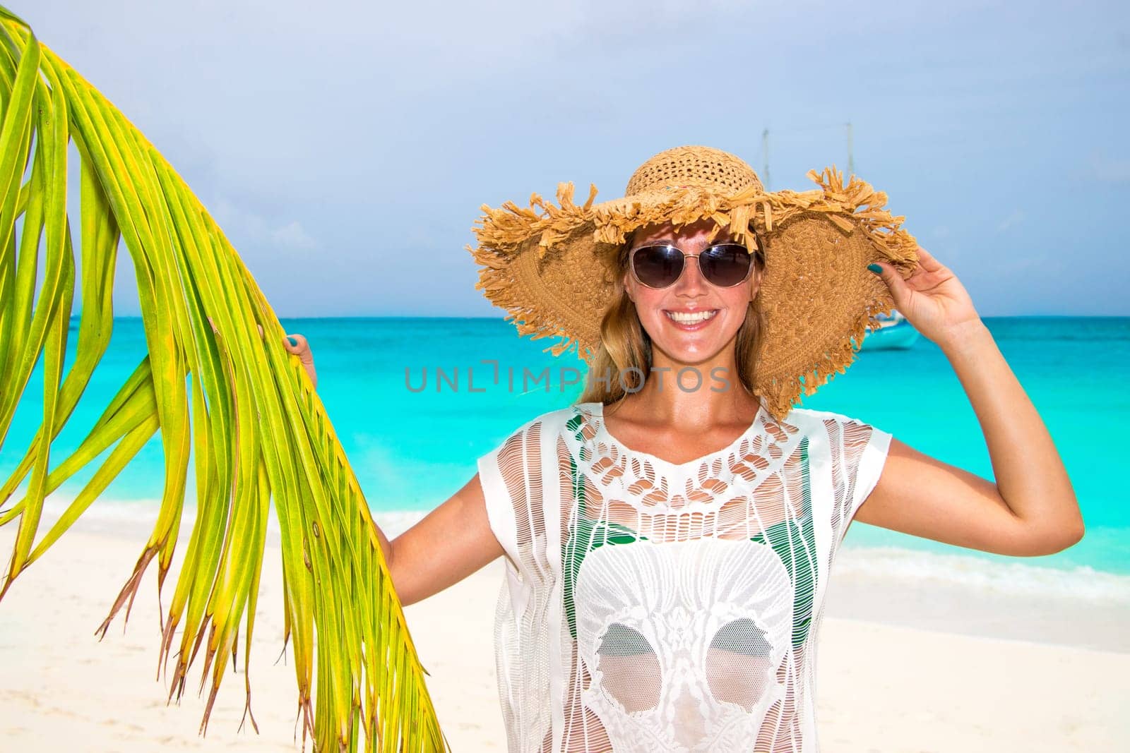 Gorgeous woman with sun hat on the dream beach