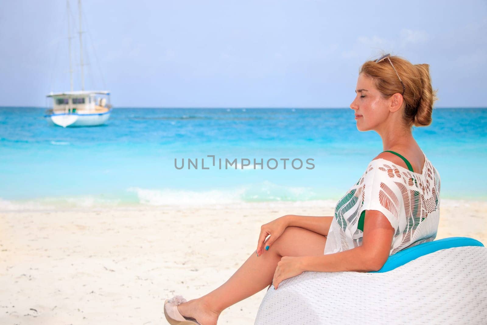 Young woman sitting on sofa at the beach