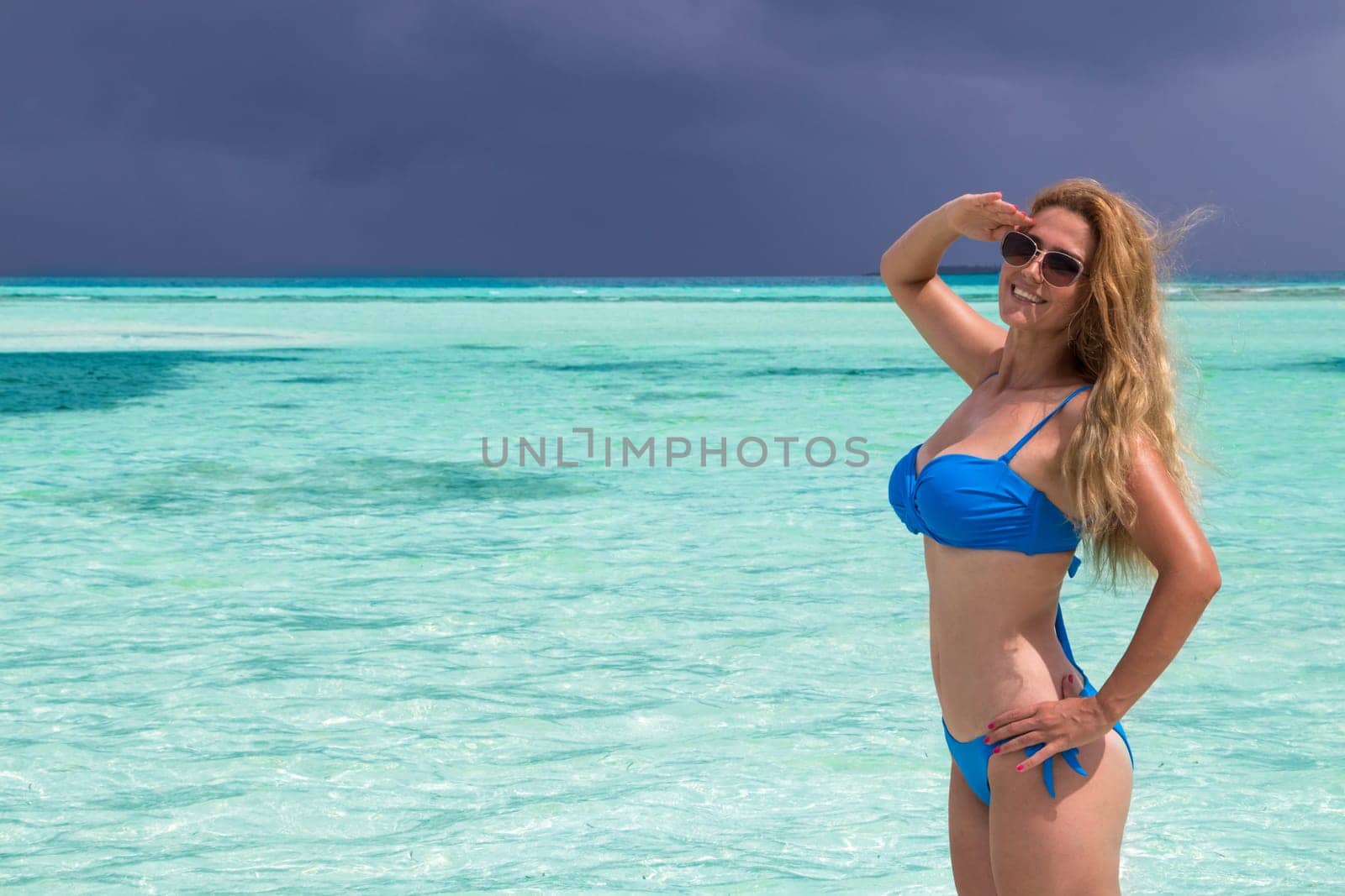 Blonde Girl in blue bikini in the turquoise sea