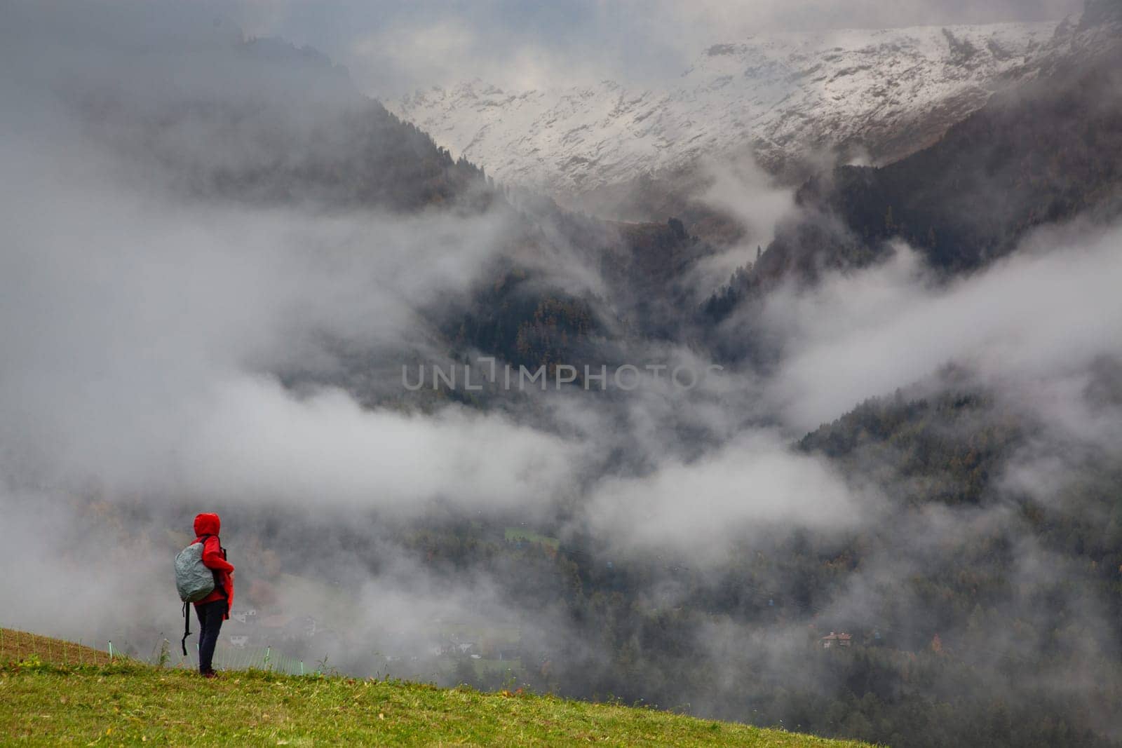 traveler in red against misty mountain peak