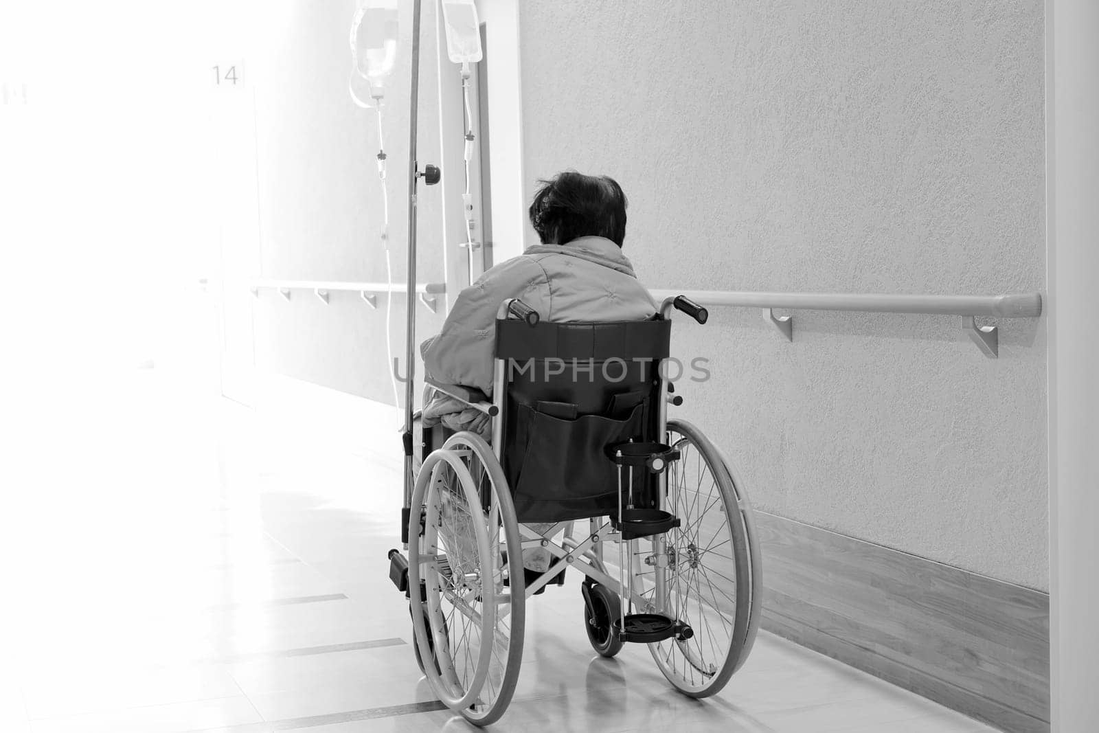 Back view of senior or elderly woman on wheelchair at hospital hallway