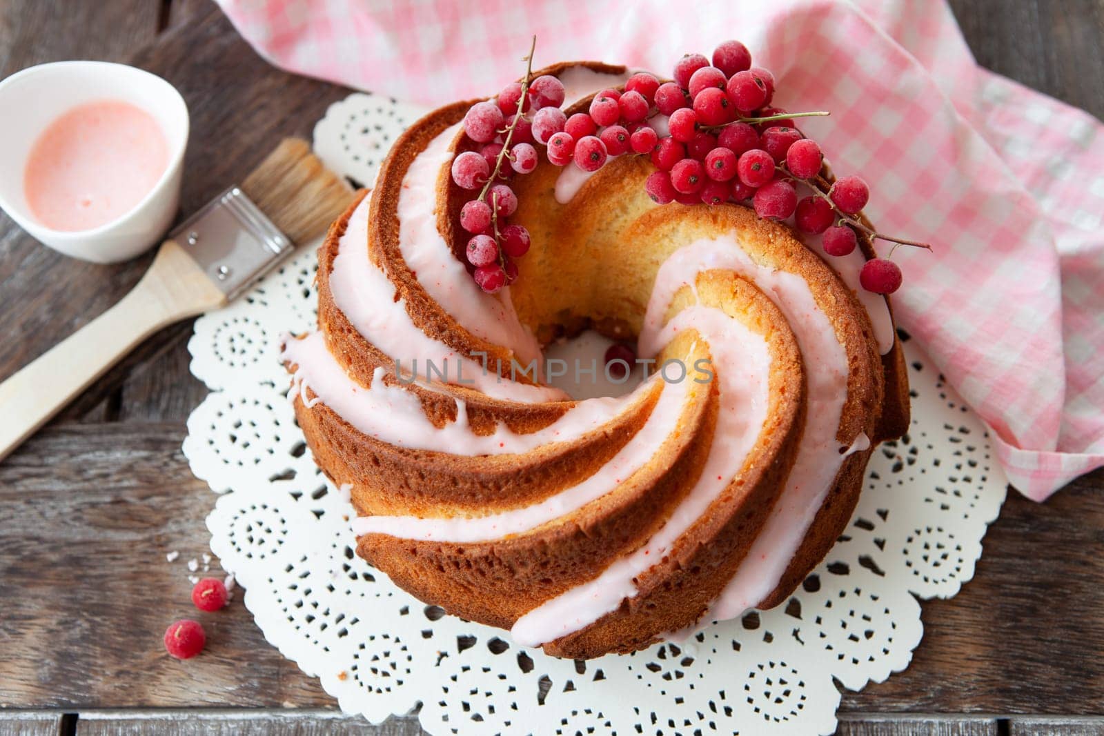 Yummy bundt cake with red currants and pink frosting