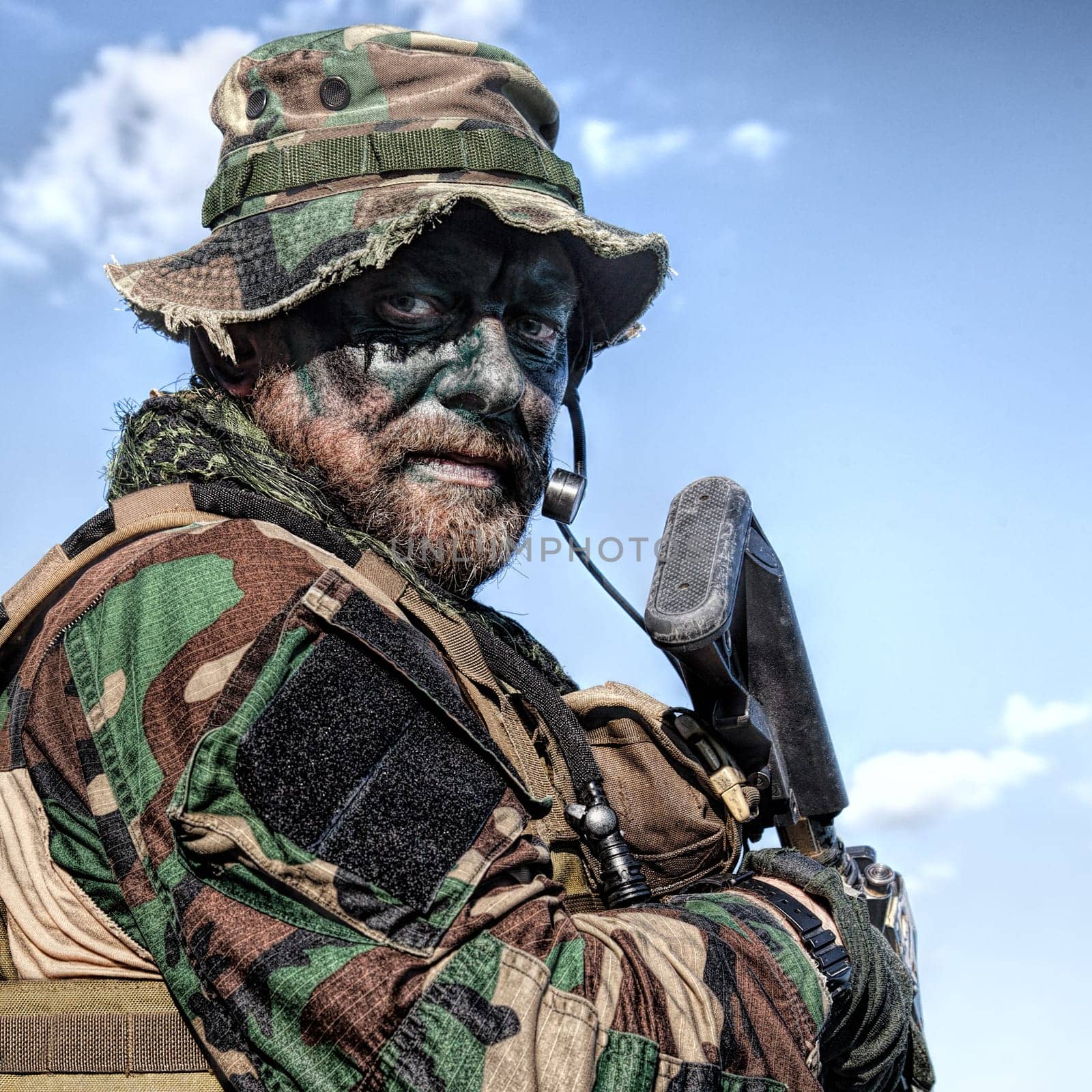 Bearded soldier of special forces on blue sky background