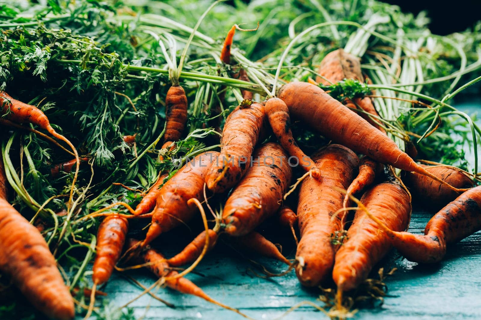lot of carrots on a wooden background.