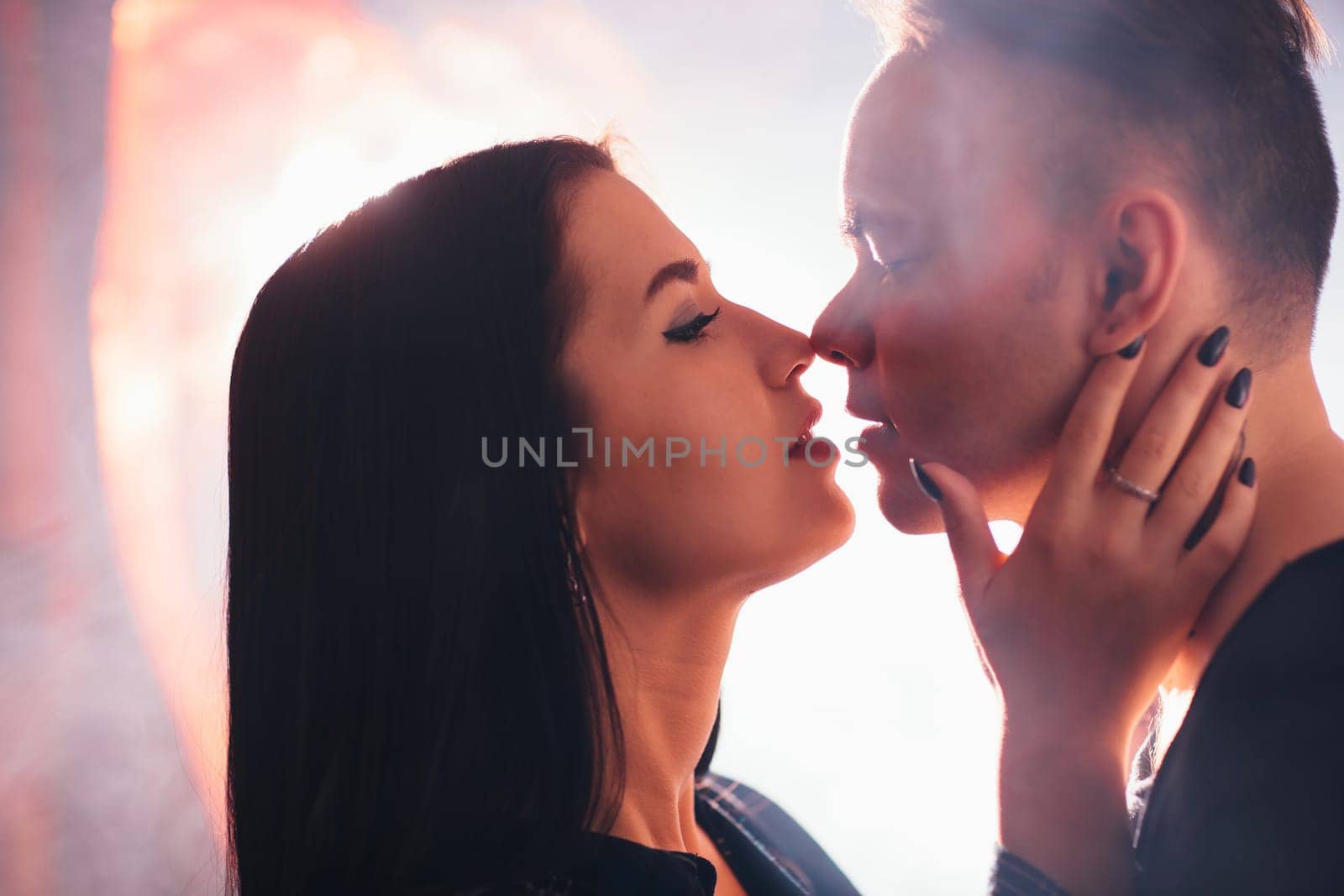 guy and the girl kiss closeup on a light background