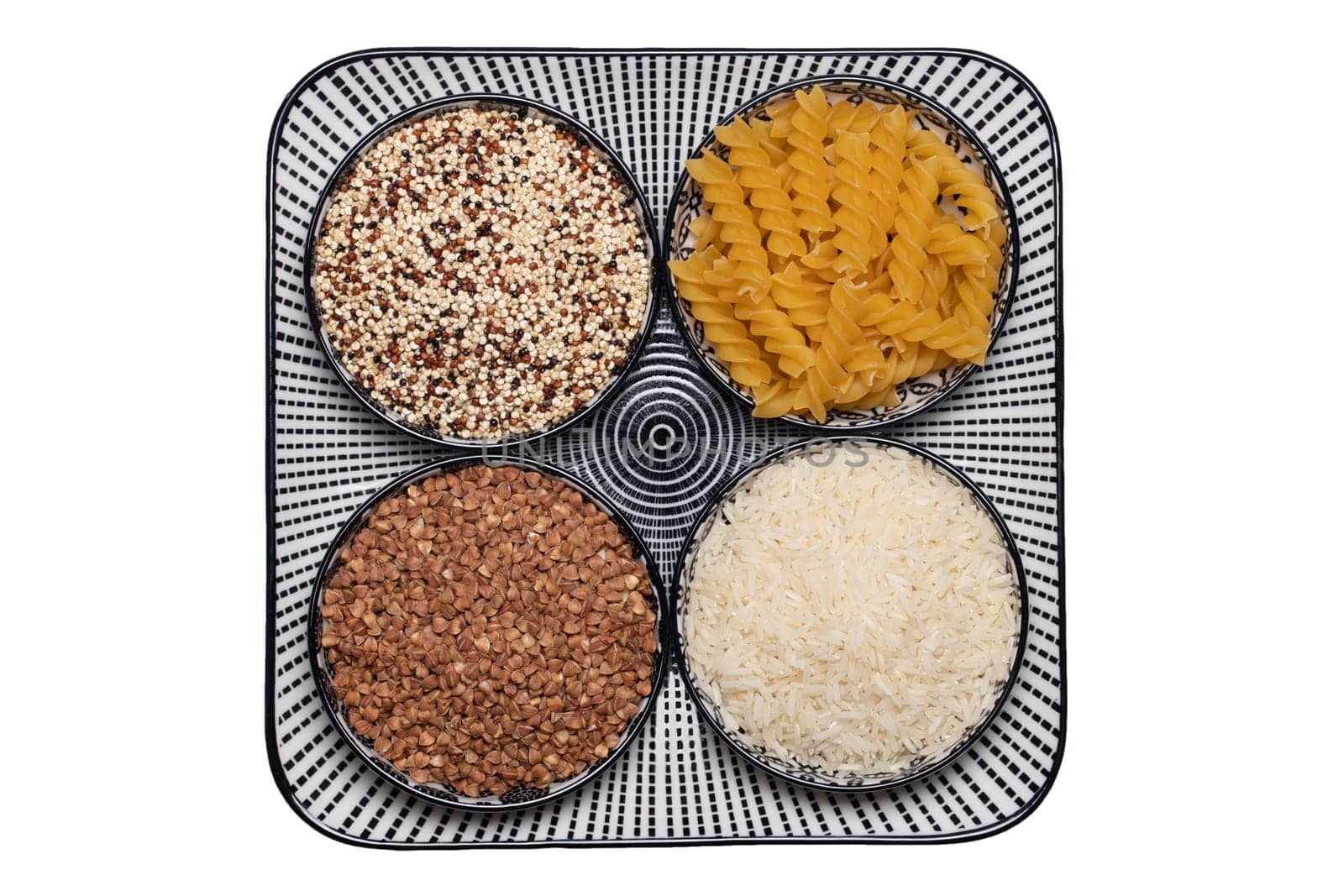 Vegetable food. Macro of a decorative plate with four bowls with buckwheat, noodles, rice and quinoa isolated on a white background. Healthy eating. Top view.
