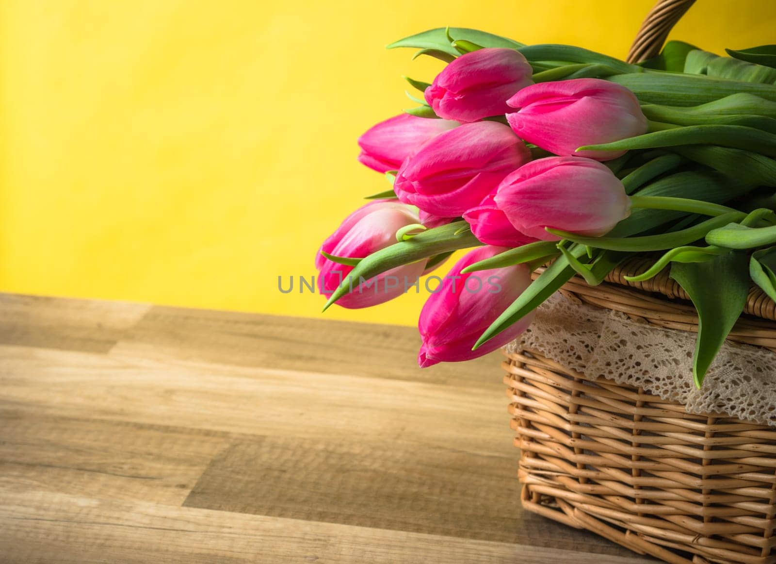 Beautiful bouquet of pink tulips in a wicker basket