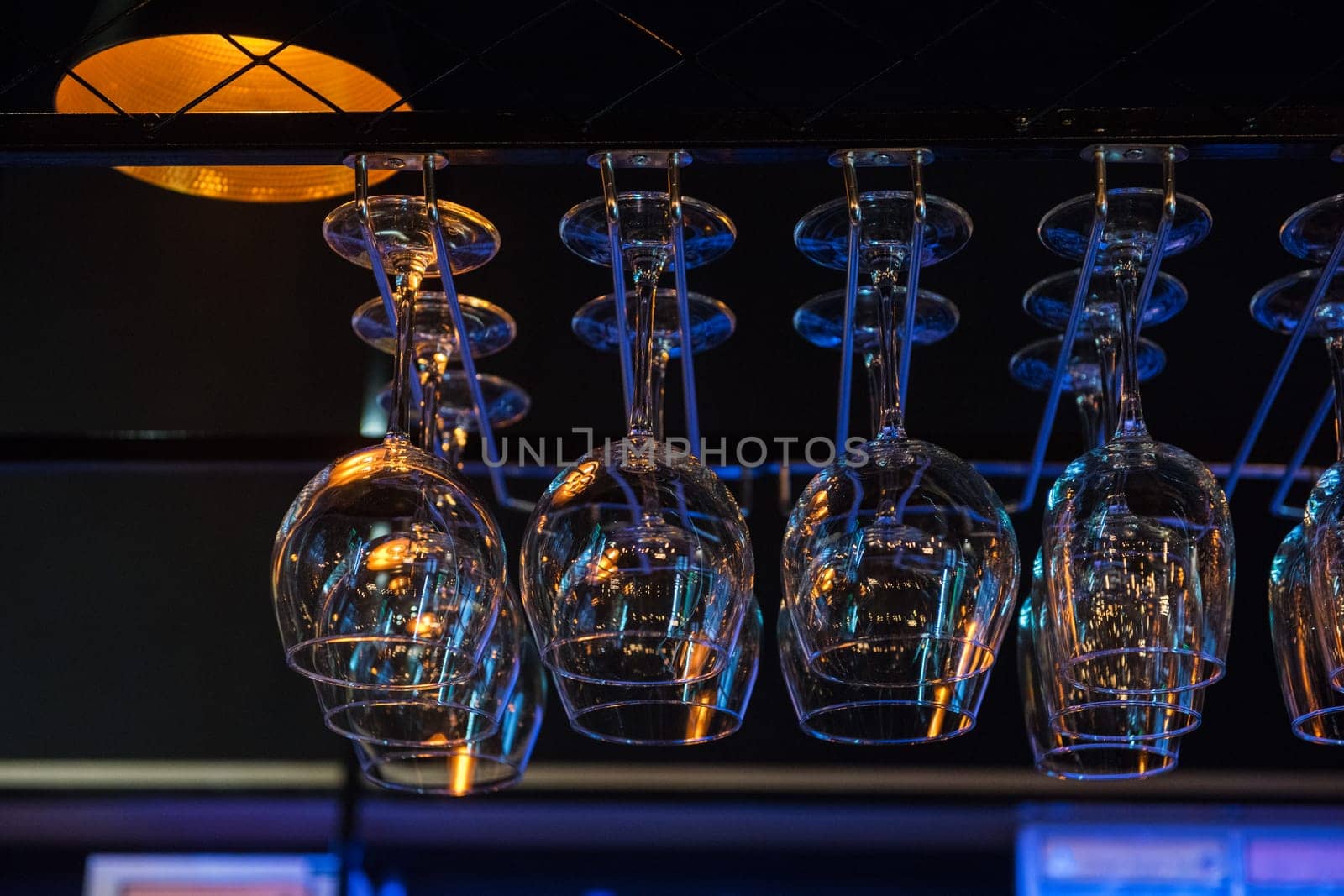 Empty clean glasses for wine above a bar rack
