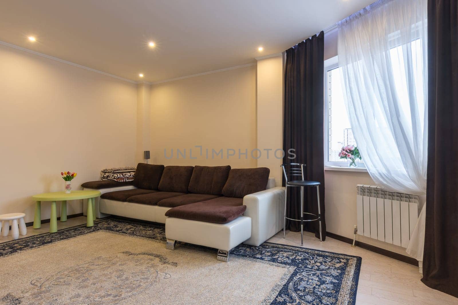 Living room interior, large sofa and window with dark curtains
