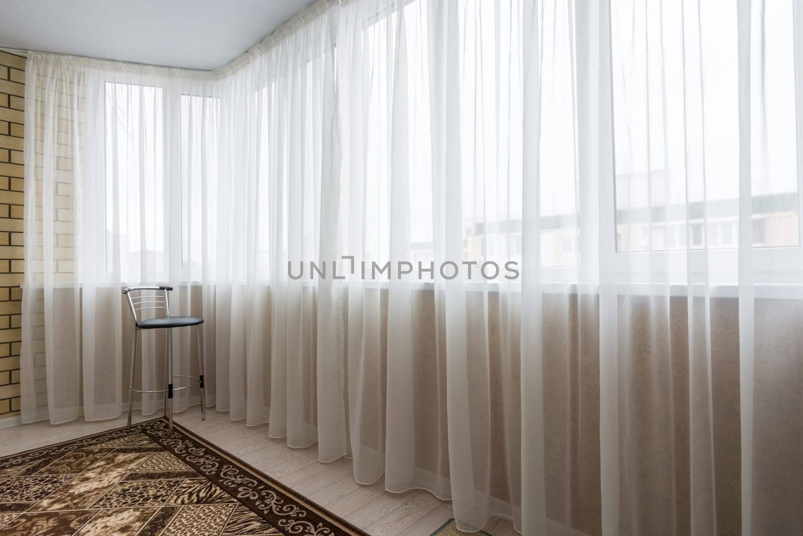 Curtained glazed spacious balcony in the apartment
