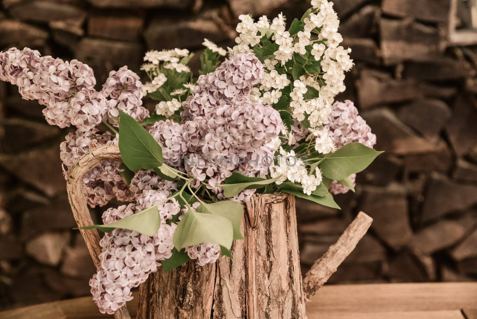 lila Flieder in einer Holzkanne Blumenstrauß