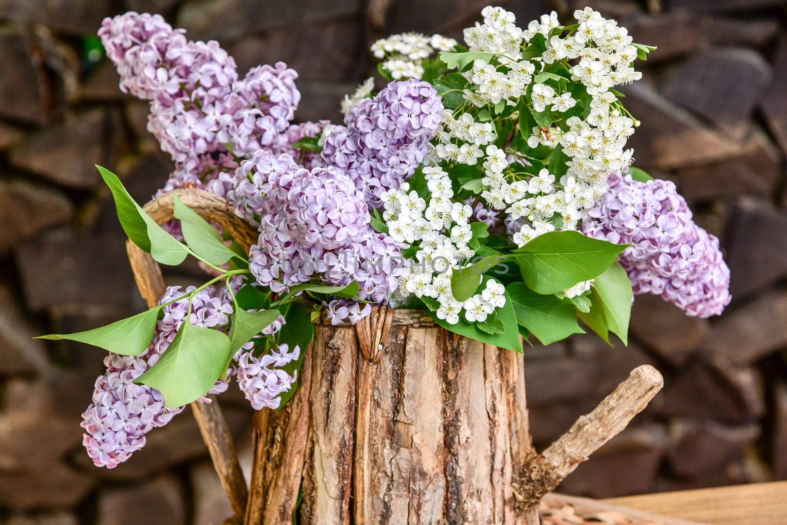lila Flieder in einer Holzkanne Blumenstrauß