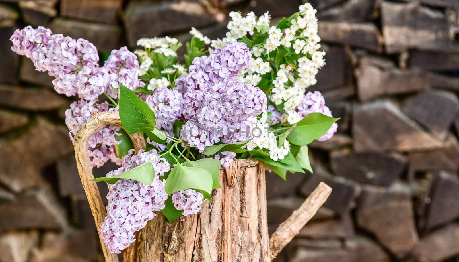 lila Flieder in einer Holzkanne Blumenstrauß