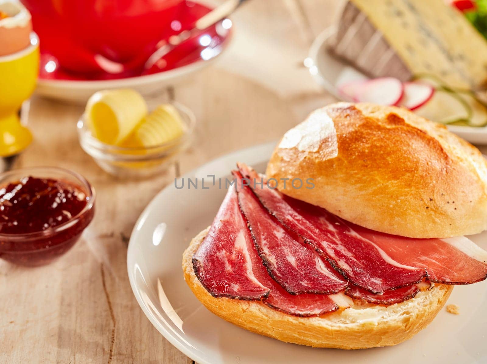 Crispy bacon in fresh white bread bun, served on white plate in a restaurant