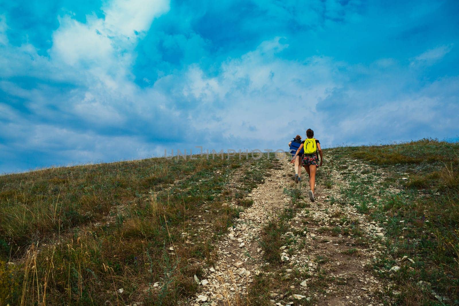 Two young girls climb into the mountains.