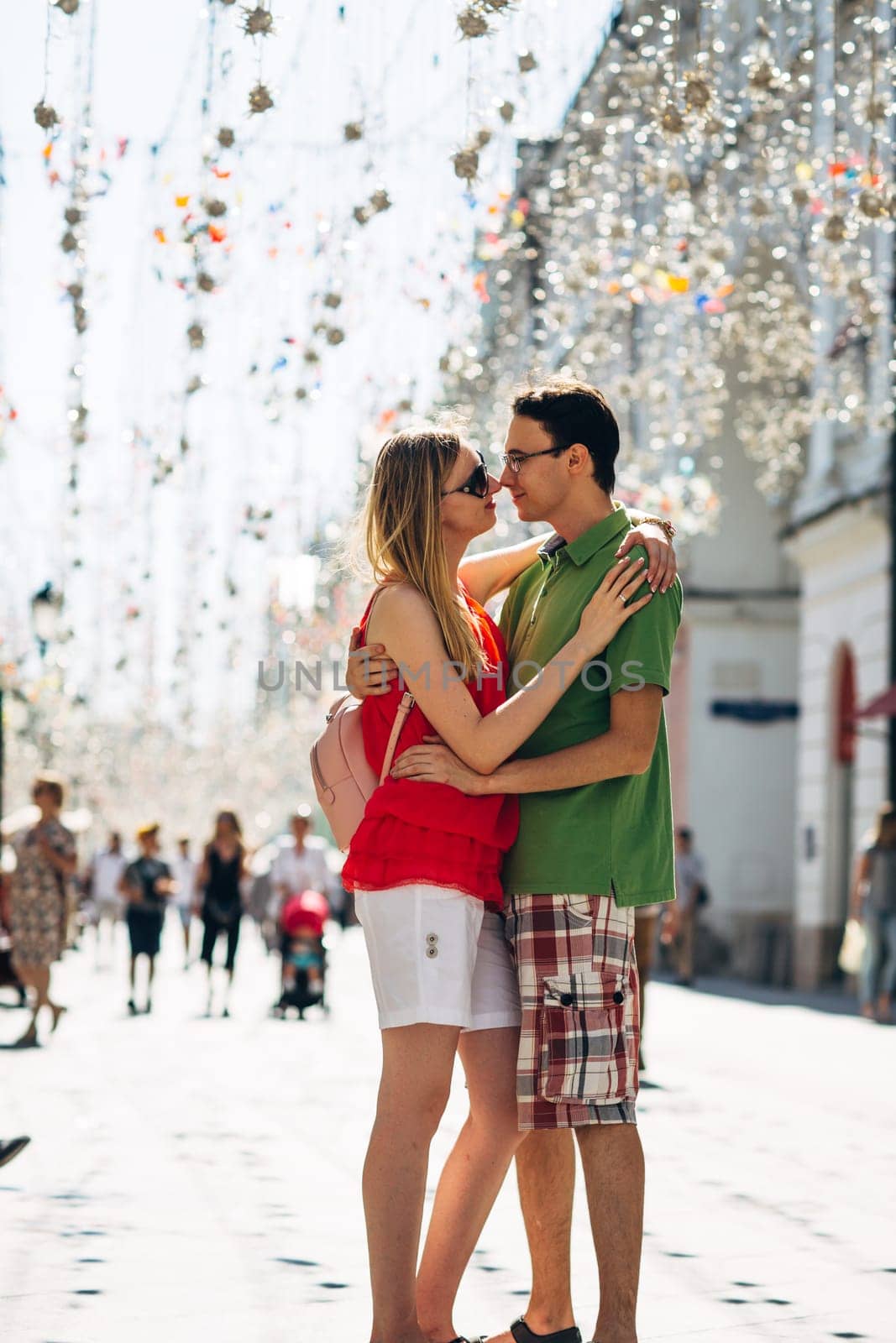 girl and guy on the background of the alley of garlands.
