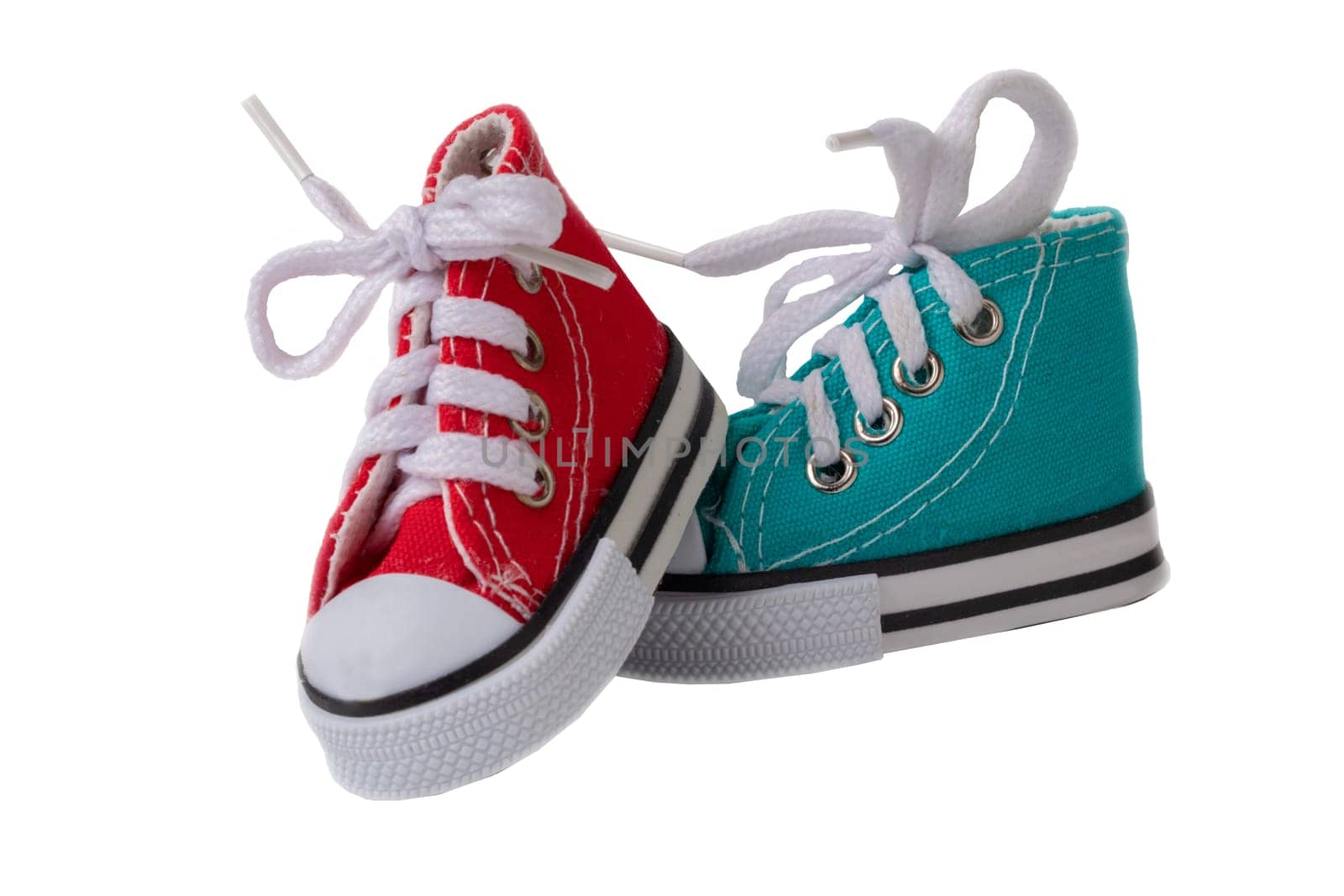 Shoes decorations background. Closeup of small colorful toy cloth shoes isolated on white background. Macro.
