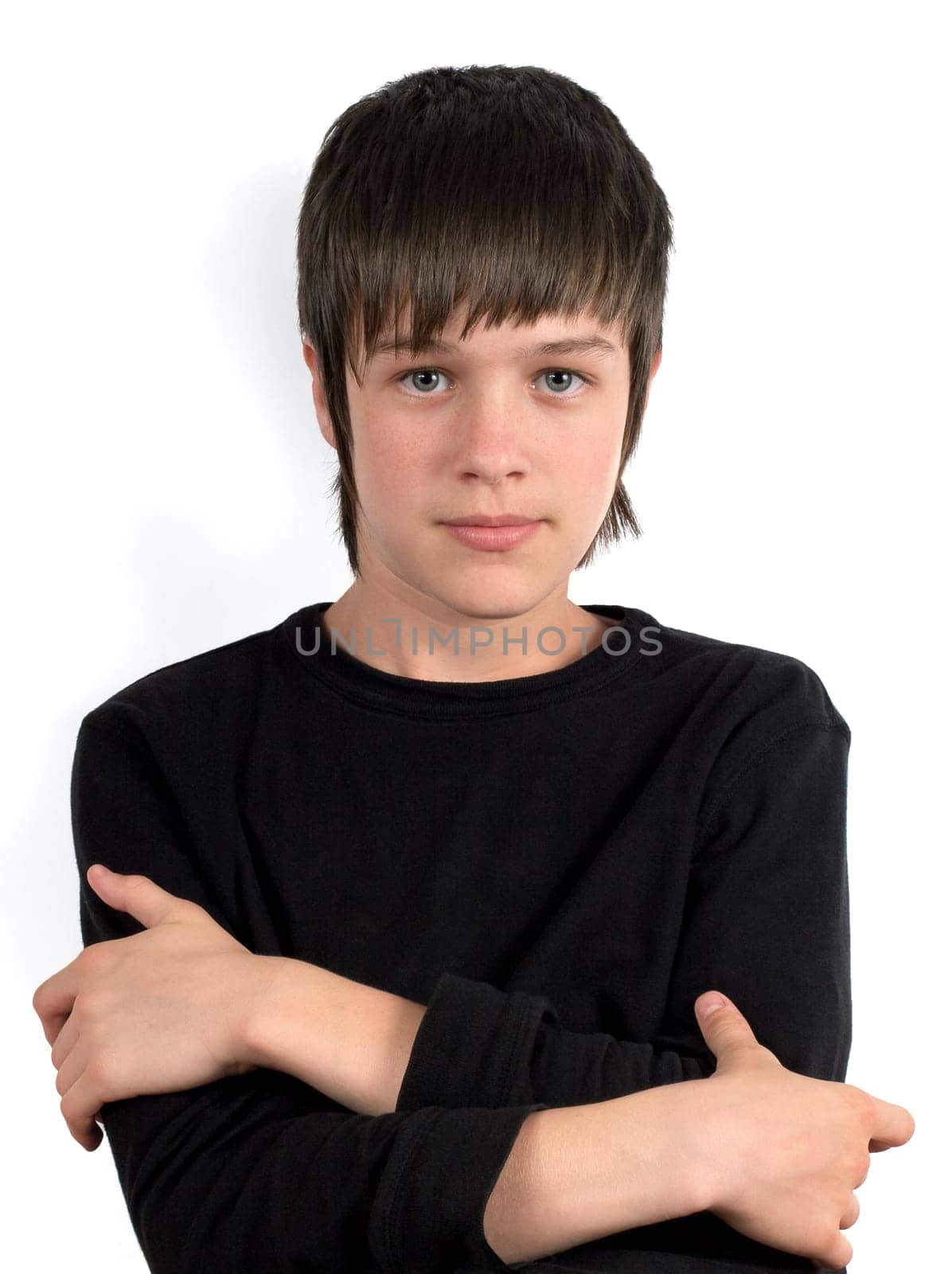 Portrait of serious teenager in black shirt with crossed hands on the chest