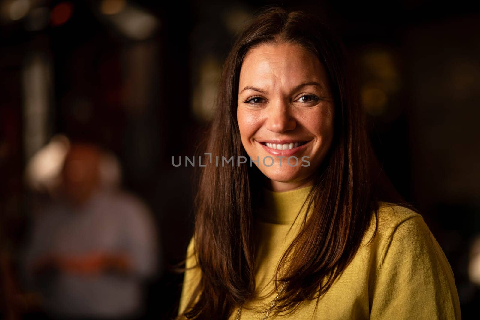 Headshot of a mature woman smiling and looking at the camera.