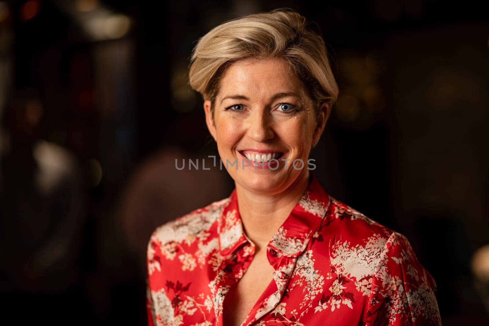 Headshot of a mature woman smiling and looking at the camera.
