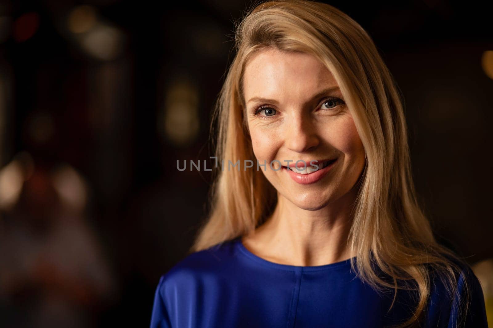 Headshot of a mature woman smiling and looking at the camera.