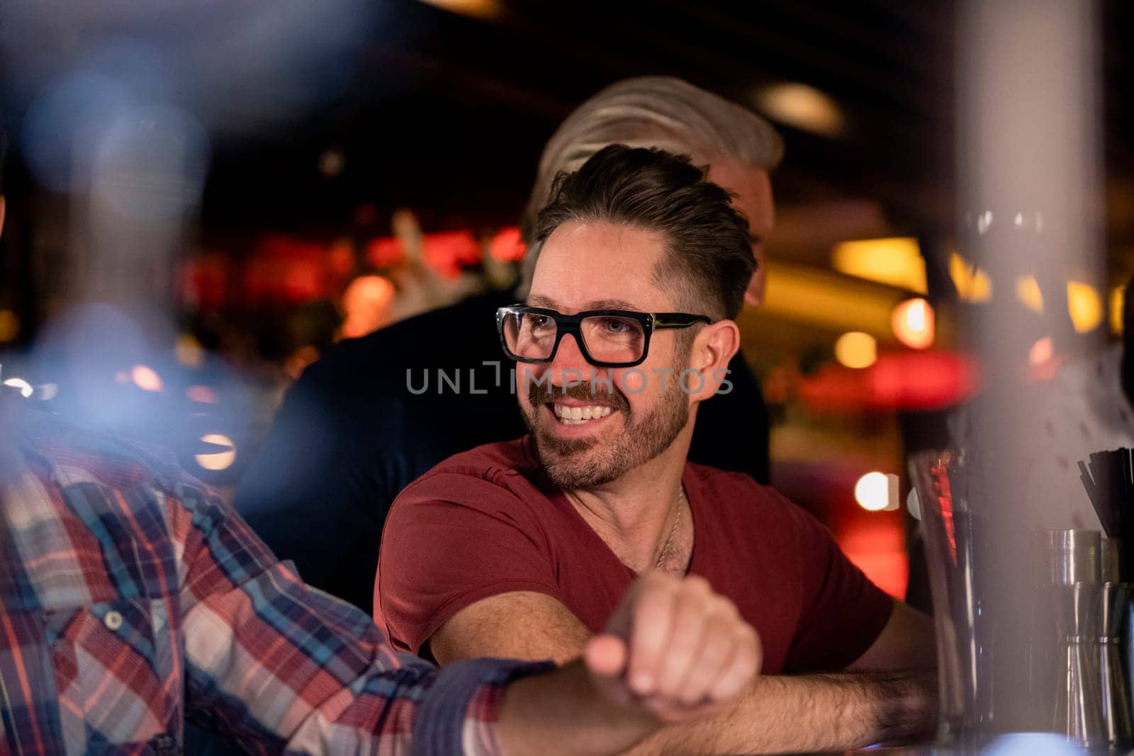 Mid adult male friends enjoying a beer together in a bar.