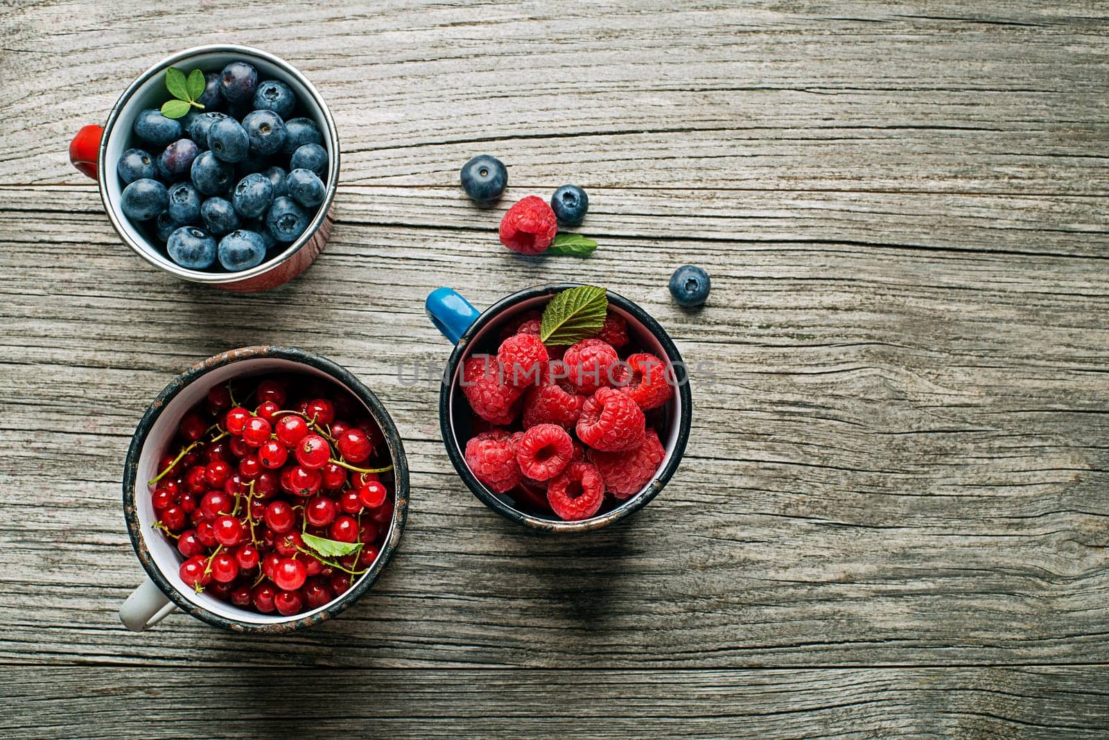 Mix of fresh berries in a bowls on wooden background