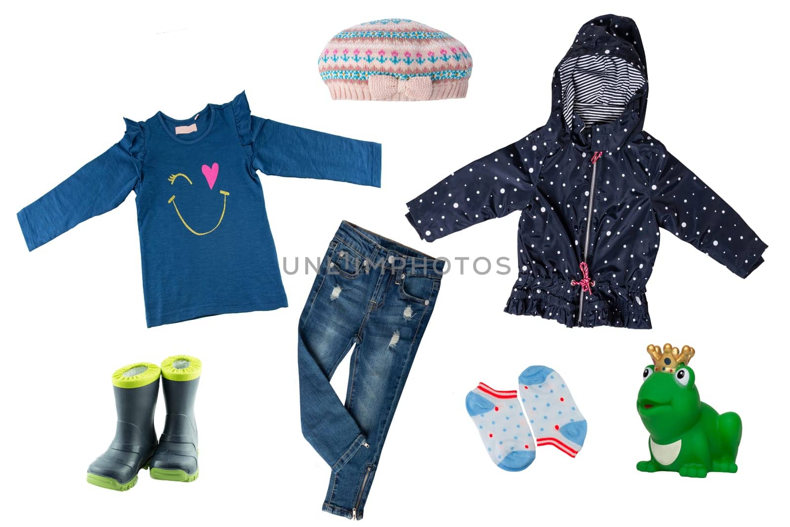 Collage set of little girl clothes isolated on a white background. The collection of a rain jacket, jeans , sweater, rubber boots, hood and socks. Childrens spring and autumn fashion.