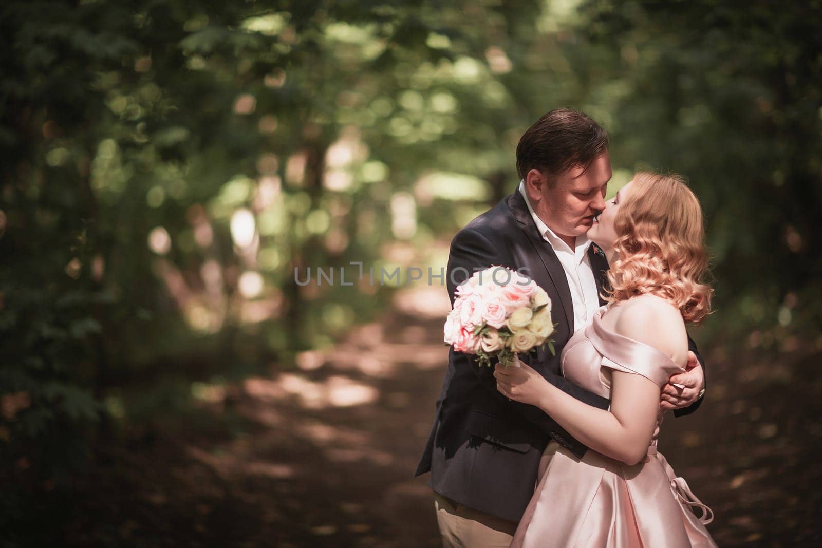 bride and groom dancing in the forest background and sunlight.