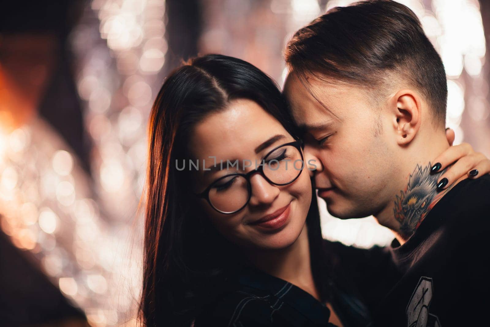 Couple in fashionable clothes on a shiny background.