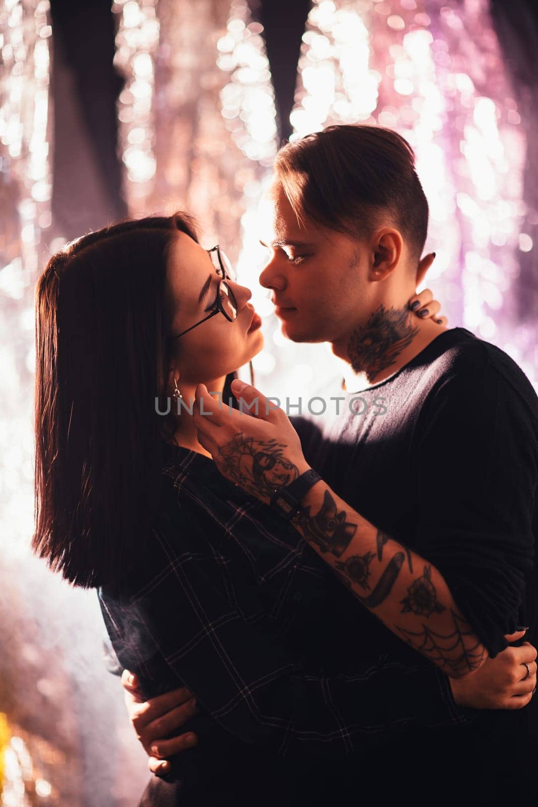 Couple in fashionable clothes on a shiny background.